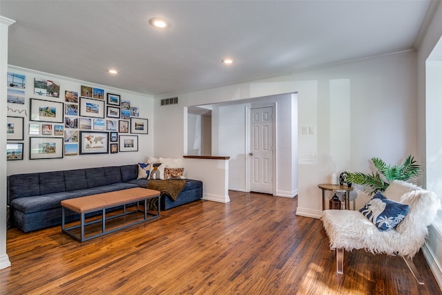 living area featuring crown molding and hardwood / wood-style flooring