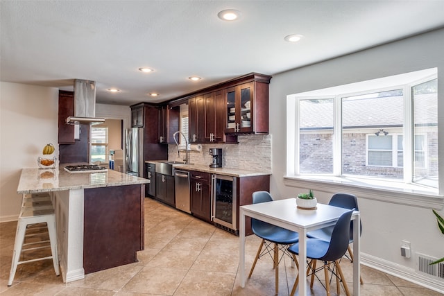 kitchen with decorative backsplash, island exhaust hood, wine cooler, appliances with stainless steel finishes, and sink