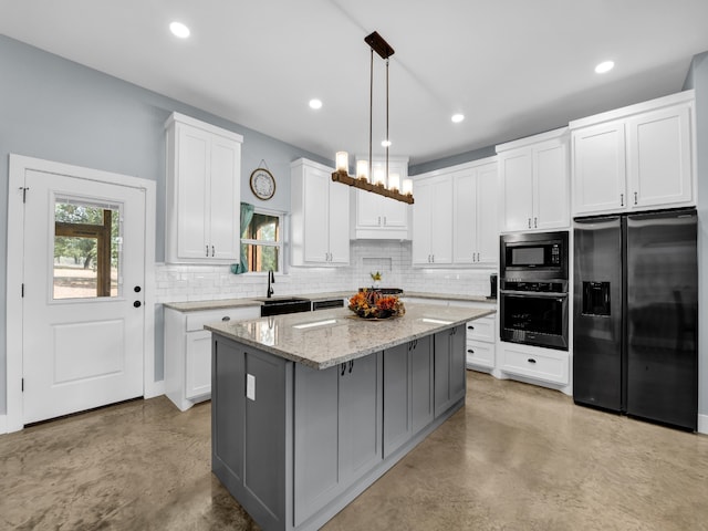 kitchen featuring pendant lighting, appliances with stainless steel finishes, a kitchen island, and finished concrete floors