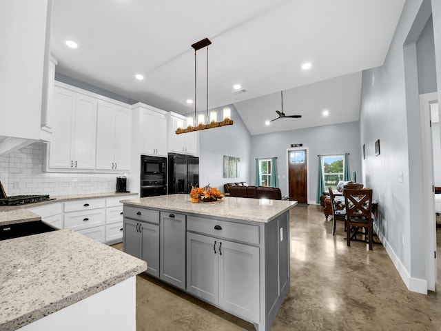 kitchen with gray cabinetry, open floor plan, a center island, black appliances, and decorative light fixtures