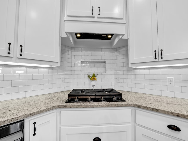 kitchen featuring tasteful backsplash, white cabinets, black gas stovetop, and light stone countertops