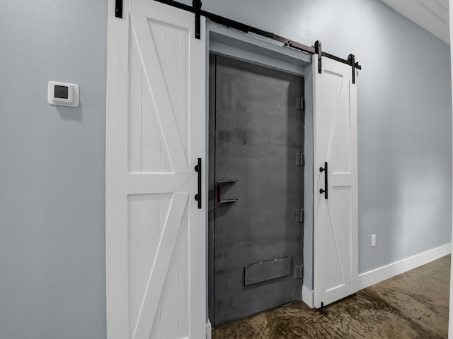 interior space featuring a barn door and baseboards