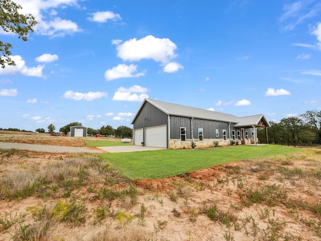 back of property with a yard, a porch, board and batten siding, a garage, and an outdoor structure