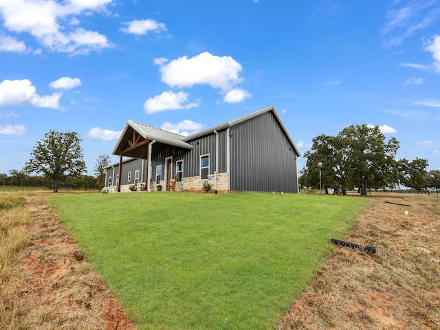 exterior space with metal roof, a yard, and board and batten siding