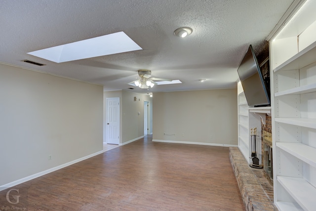 unfurnished living room with a textured ceiling, vaulted ceiling, a wealth of natural light, and ceiling fan