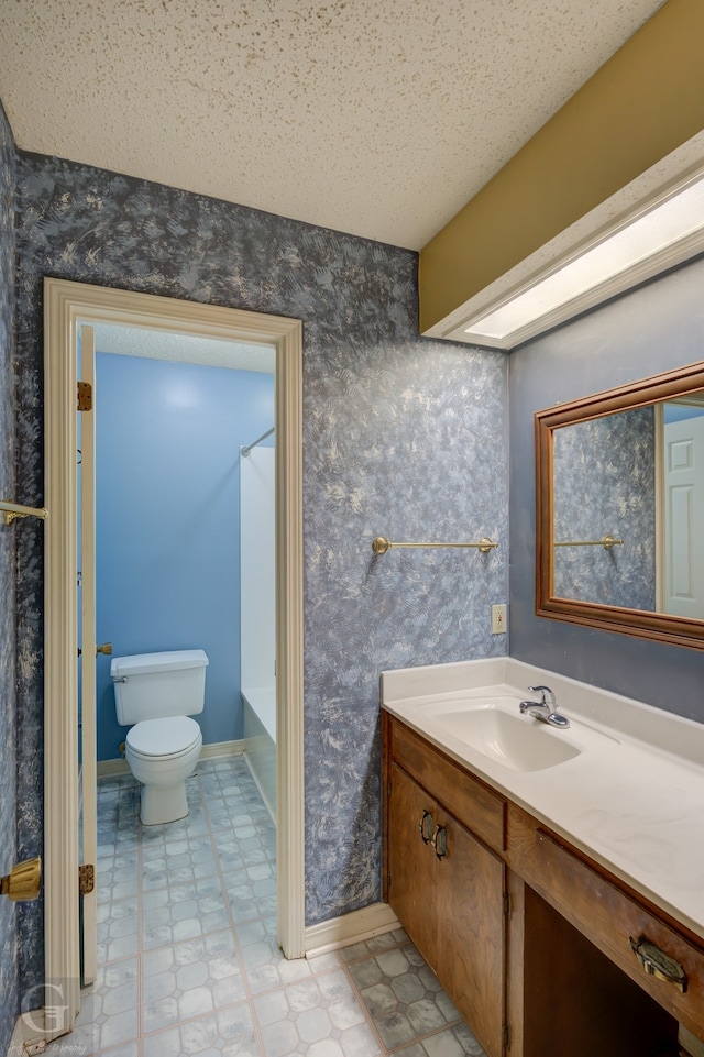 unfurnished bedroom with ensuite bath, light colored carpet, a textured ceiling, and a closet