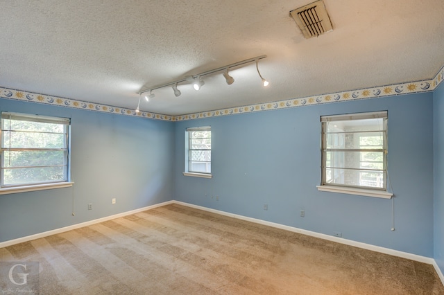 empty room with a textured ceiling, ceiling fan, and light carpet