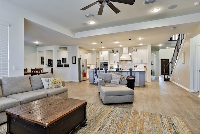 living room featuring light hardwood / wood-style flooring and ceiling fan