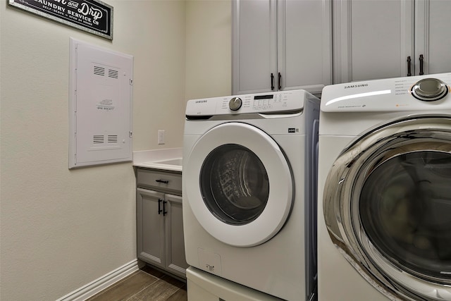 laundry area featuring cabinets, dark hardwood / wood-style floors, and separate washer and dryer