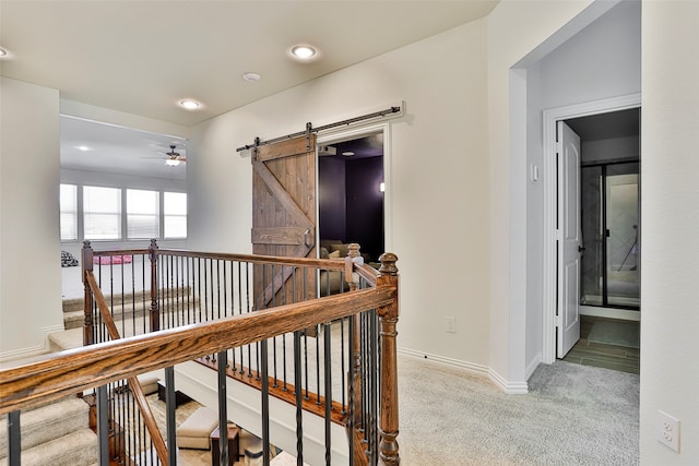 hall with light carpet and a barn door