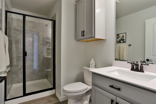 bathroom featuring toilet, an enclosed shower, hardwood / wood-style floors, and vanity