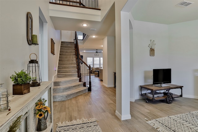 foyer featuring a high ceiling, light hardwood / wood-style flooring, and ceiling fan