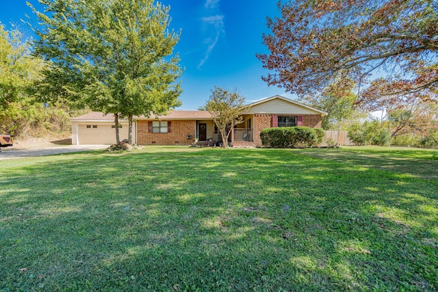 ranch-style home featuring covered porch, a front yard, and a garage