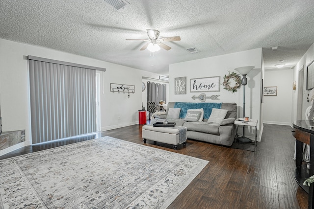 living room with a textured ceiling, dark hardwood / wood-style floors, and ceiling fan