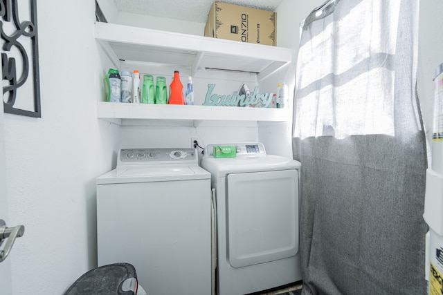 laundry area with a textured ceiling and washing machine and clothes dryer