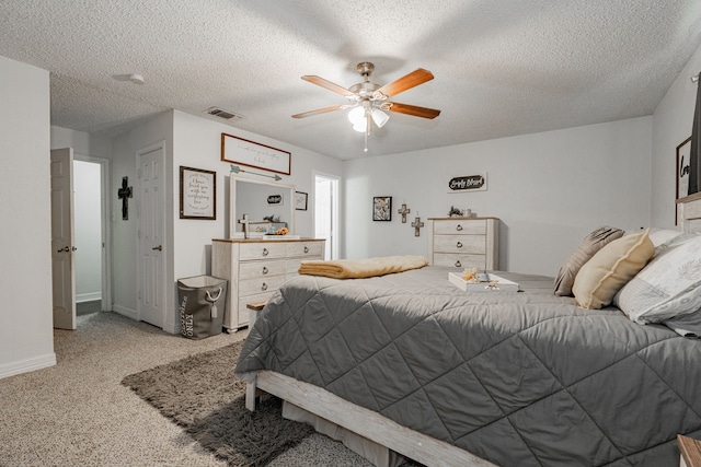 carpeted bedroom with ceiling fan and a textured ceiling