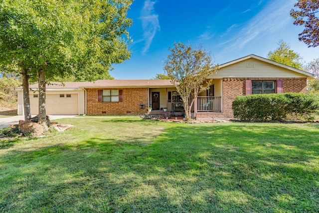 ranch-style home with covered porch, a garage, and a front yard