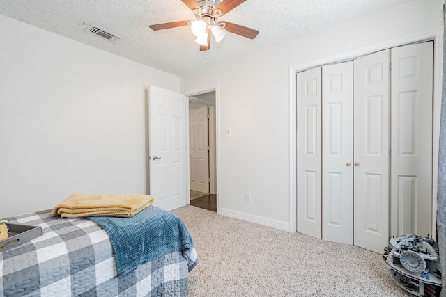 bedroom featuring carpet flooring, a textured ceiling, and ceiling fan