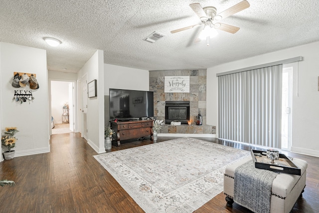 living room with dark wood-type flooring, a textured ceiling, and ceiling fan