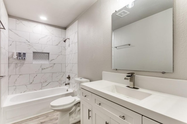 full bathroom featuring a textured wall, toilet, washtub / shower combination, vanity, and wood finished floors