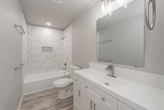 full bathroom with vanity, tiled shower / bath, hardwood / wood-style flooring, and toilet