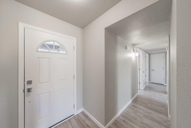 foyer featuring a textured ceiling and light hardwood / wood-style floors