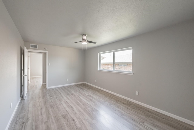 empty room with ceiling fan, a textured ceiling, and light hardwood / wood-style flooring