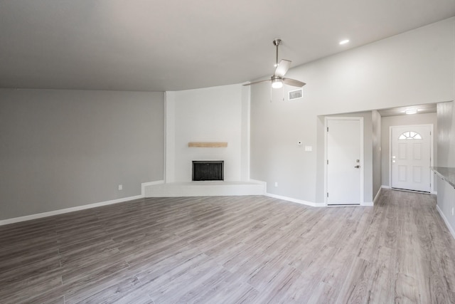 unfurnished living room featuring high vaulted ceiling, light wood-type flooring, and ceiling fan