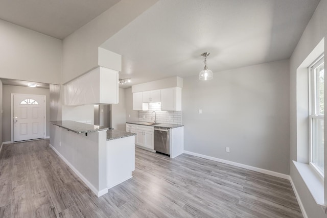 kitchen featuring dishwasher, kitchen peninsula, sink, white cabinetry, and light hardwood / wood-style floors