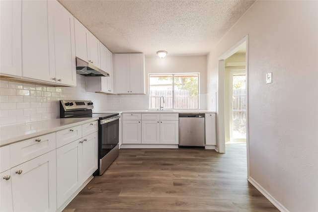 kitchen with appliances with stainless steel finishes, white cabinets, sink, and dark wood-type flooring