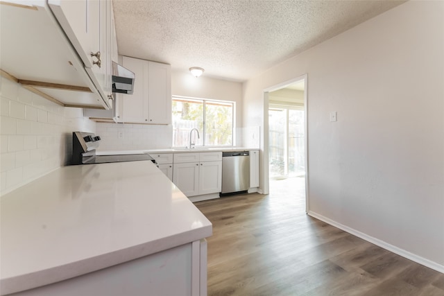 kitchen featuring white cabinets, stainless steel dishwasher, wood-type flooring, black range, and sink