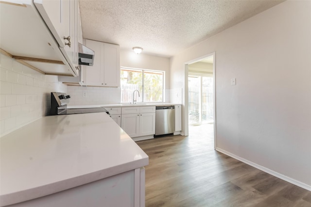 5037 Collingwood Dr, Garland, TX 75043 - kitchen with exhaust hood, tasteful backsplash, a sink, white cabinets, and stainless steel appliances