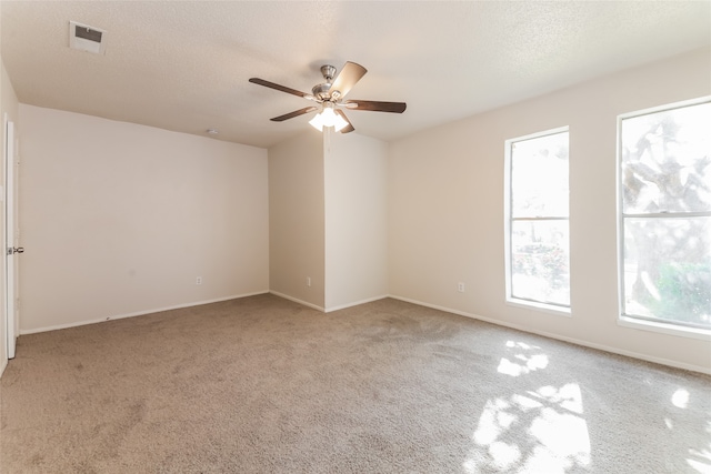 carpeted empty room with a textured ceiling and ceiling fan