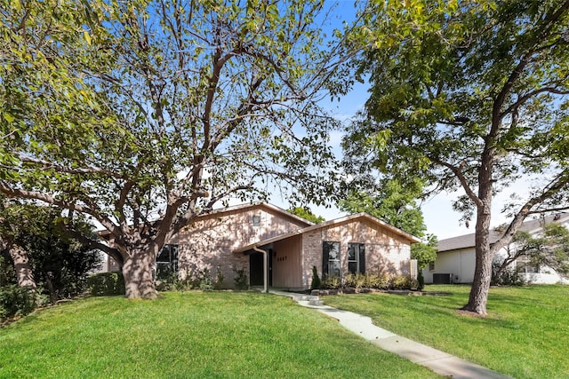 single story home featuring a front lawn and central air condition unit