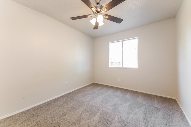 carpeted spare room featuring a textured ceiling and ceiling fan