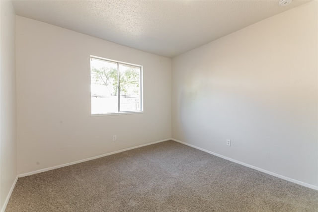 unfurnished room featuring carpet and a textured ceiling