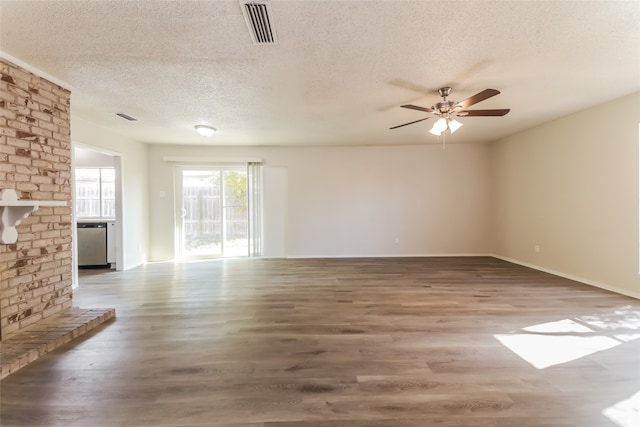 unfurnished living room with ceiling fan, a textured ceiling, a brick fireplace, and hardwood / wood-style floors