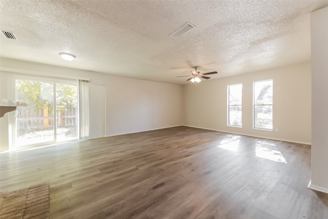 spare room featuring hardwood / wood-style floors, a healthy amount of sunlight, and a textured ceiling