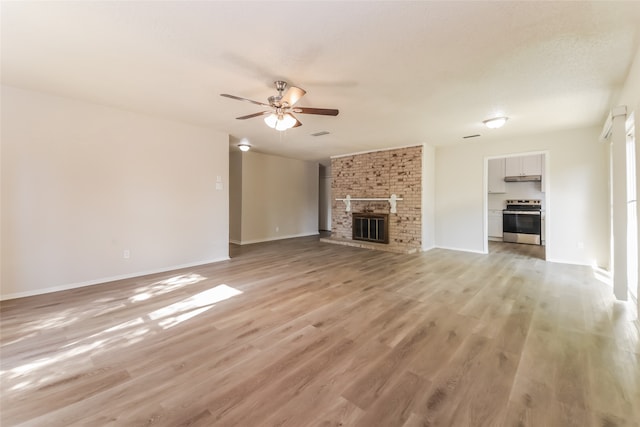 unfurnished living room with light hardwood / wood-style flooring, a brick fireplace, and ceiling fan