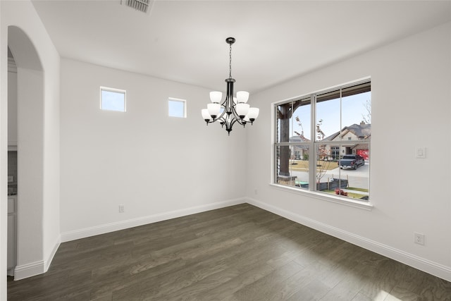 unfurnished dining area with a notable chandelier and dark hardwood / wood-style flooring