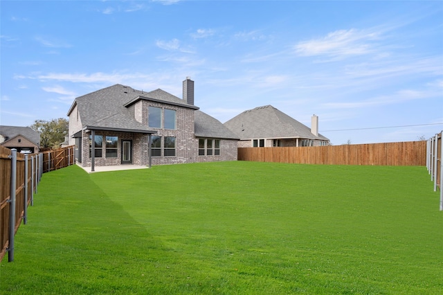 rear view of property with a yard and a patio