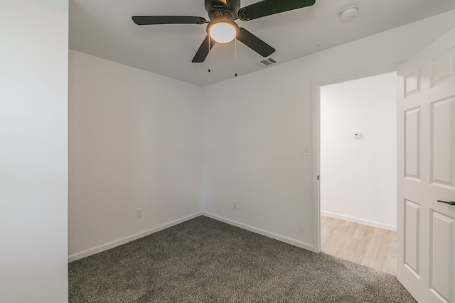 carpeted spare room featuring ceiling fan