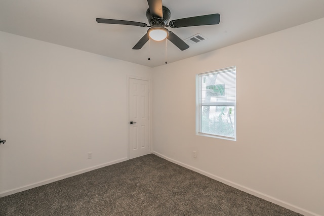 empty room with dark carpet and ceiling fan