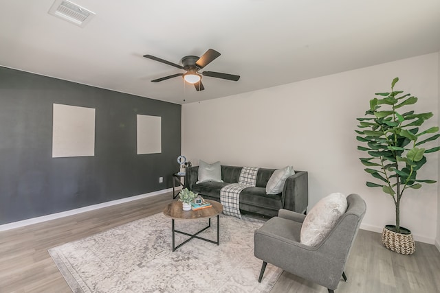 living room featuring wood-type flooring and ceiling fan