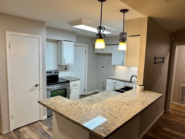 kitchen with stainless steel electric stove, tasteful backsplash, white cabinetry, light stone countertops, and sink