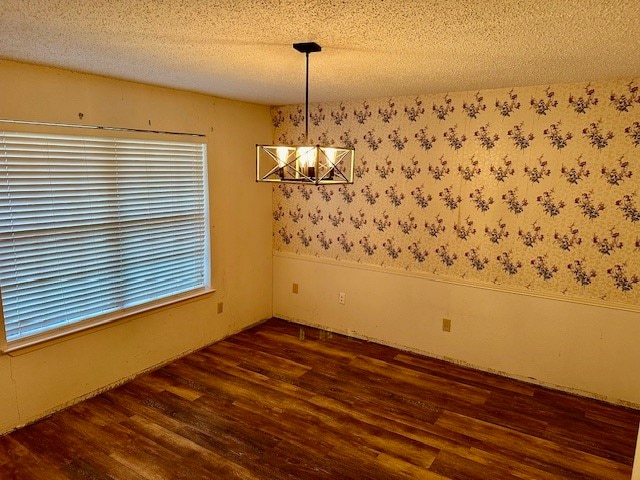 empty room featuring a textured ceiling and dark hardwood / wood-style flooring