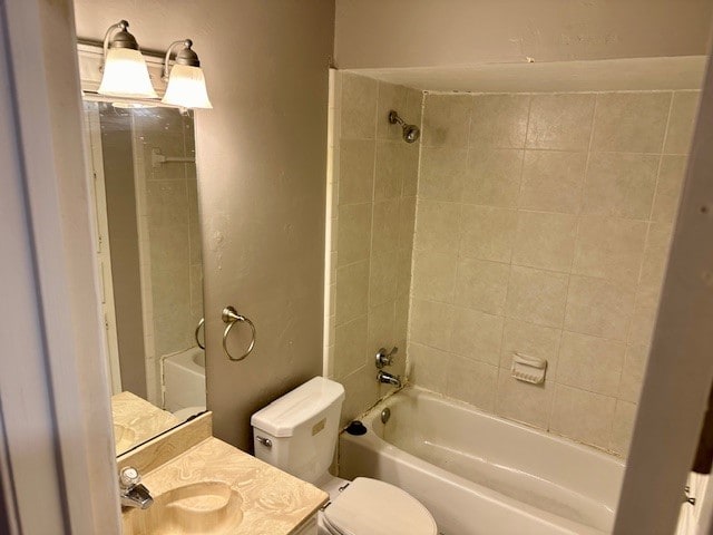 full bathroom with toilet, tiled shower / bath combo, and vanity