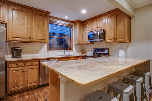 kitchen with a kitchen breakfast bar, stainless steel appliances, dark hardwood / wood-style floors, and tasteful backsplash