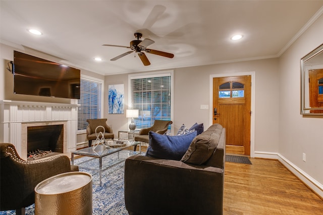 living room with light hardwood / wood-style flooring, ceiling fan, and crown molding