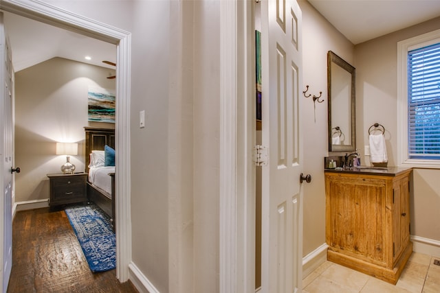 hall featuring lofted ceiling, sink, and light hardwood / wood-style floors